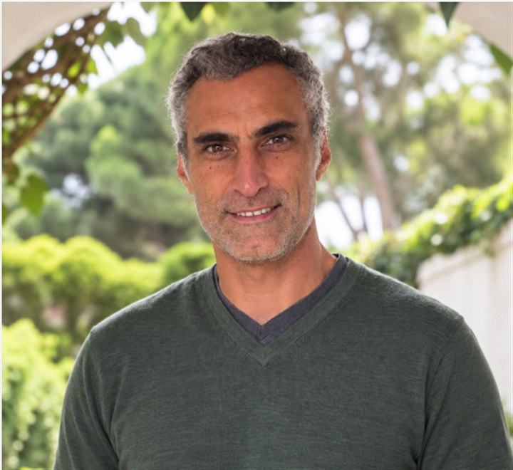 Guy Winckler, créateur et accompagnateur de PARTS, souriant sous une arche de verdure.